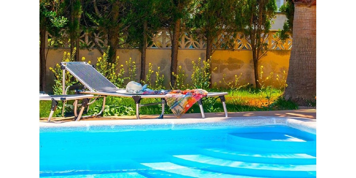 Diseño de la esquina fresca y encantadora con tumbonas palma pie hasta el borde de la piscina..