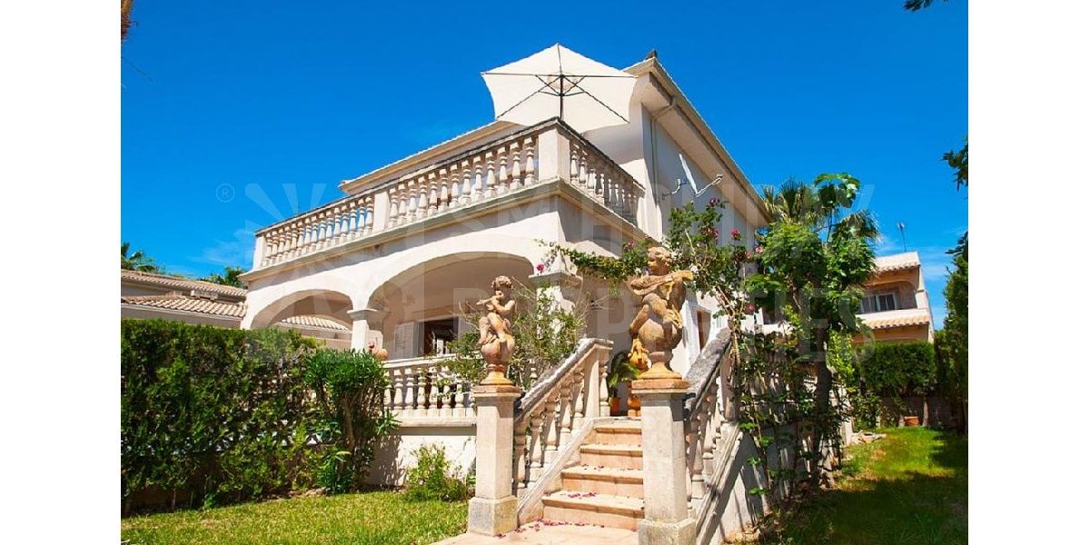 Fachada de la maravillosa villa con escalera de piedra flanqueada por querubines.