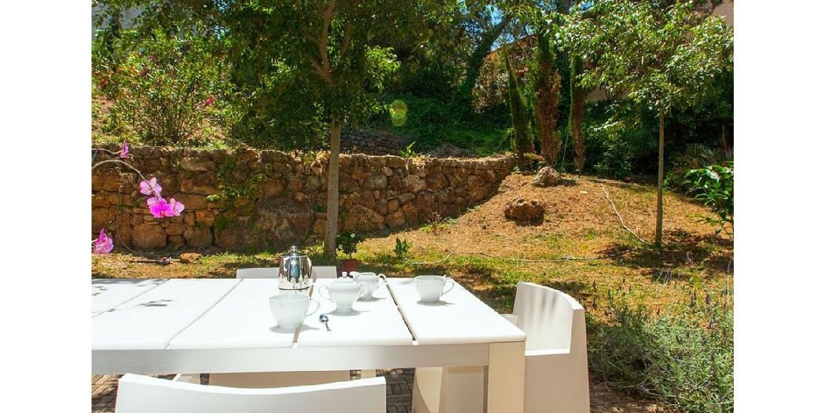 Zona de comedor al aire libre en el fragante patio de paisaje mediterráneo.