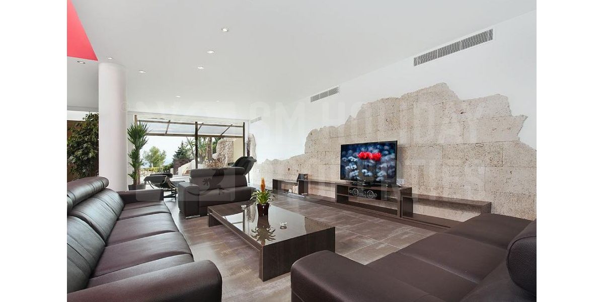 Amplio salón con confortable zona de sofás de piel,TV plana y vistas al mar.