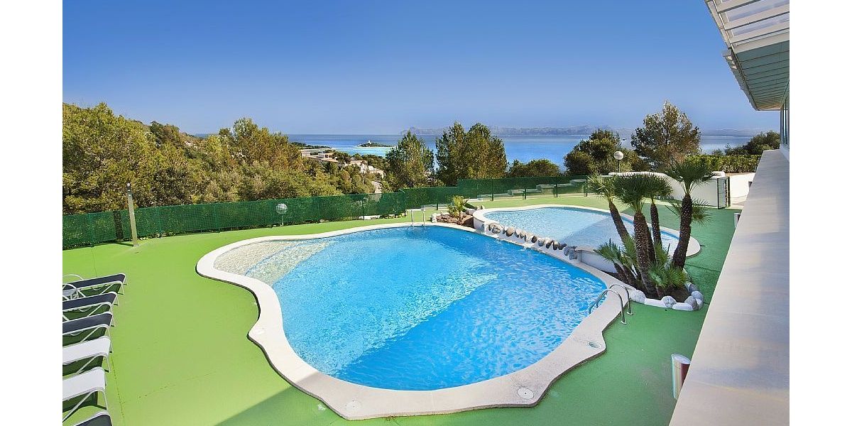 Fabulosa piscina con zona de adultos y niños, línea de hamacas y vistas al mar.