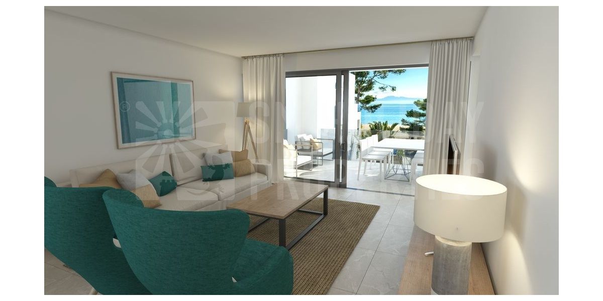 Salón con cómodos sofás y salida a la terraza con vistas al mar y a la playa.